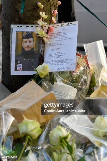 Photo of the fallen police officer is placed with flowers on the Champs Elysees the day after a gunman opened fire on police officers on April 21,...