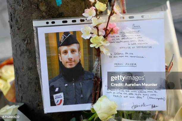 Photo of the fallen police officer is placed with flowers on the Champs Elysees the day after a gunman opened fire on police officers on April 21,...