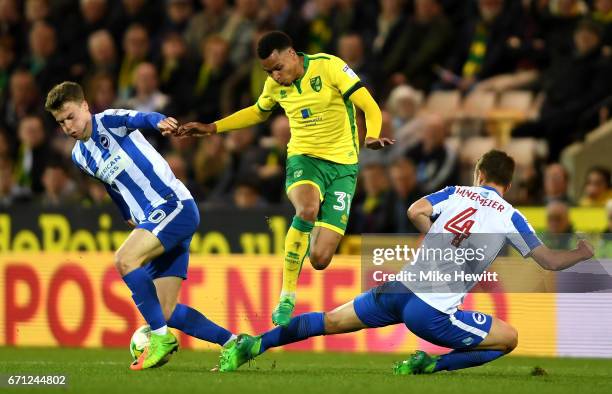 Josh Murphy of Norwich City takes on Uwe Hunemeier of Brighton and Hove Albion and Solly March of Brighton and Hove Albion during the Sky Bet...