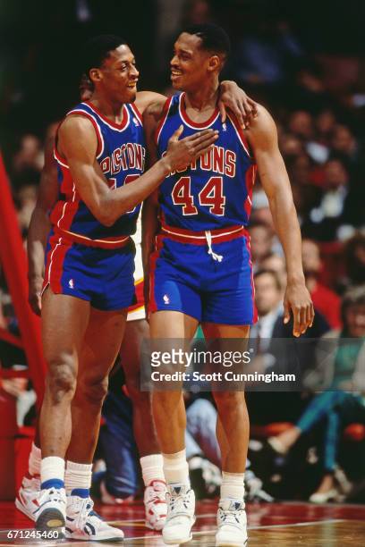 Dennis Rodman and Rick Mahorn of the Detroit Pistons hug against the Atlanta Hawks during a game played circa 1990 at the Omni in Atlanta, Georgia....