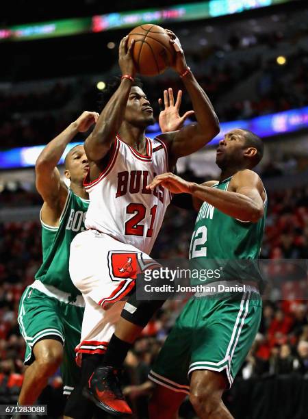 Jimmy Butler of the Chicago Bulls drives between Avery Bradley and Al Horford of the Boston Celtics during Game Three of the Eastern Conference...