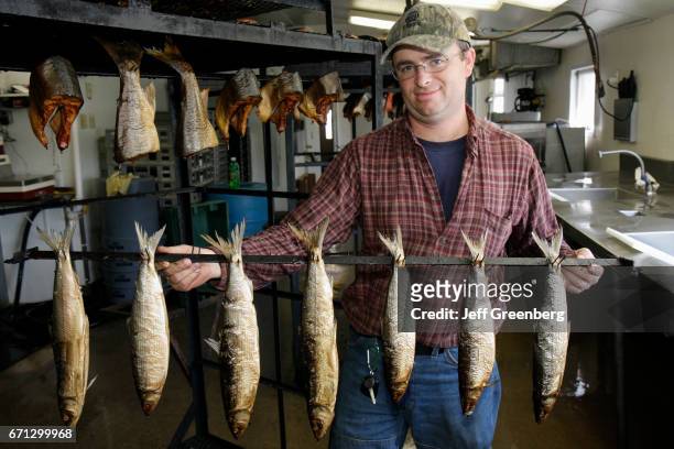 Man holding a rack of smoked fish at Thill's Fish House.