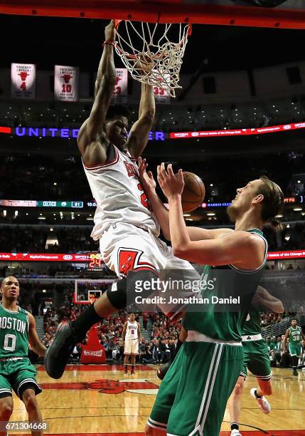 Jimmy Butler of the Chicago Bulls dunks over Kelly Olynyk of the Boston Celtics during Game Three of the Eastern Conference Quarterfinals during the...