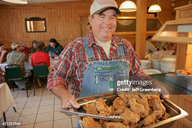 Man holding a tray of fried chicken at Mockingbird Grill.