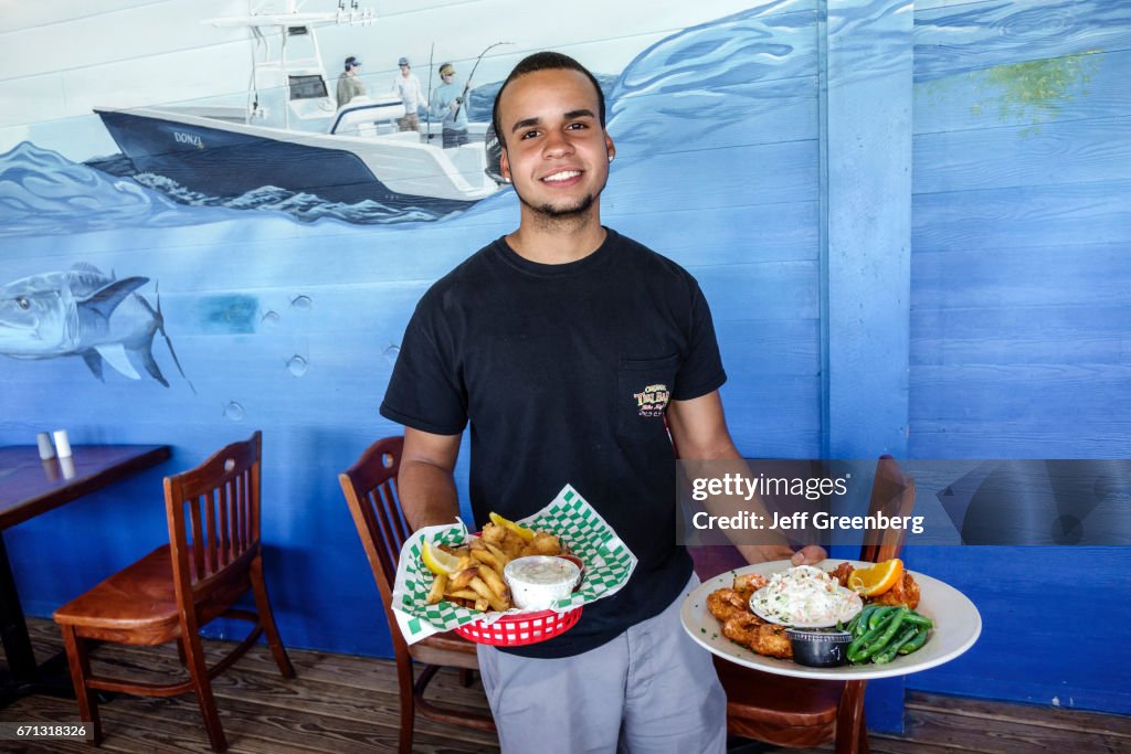 A waiter serving food at Original Tiki Bar & Restaurant.