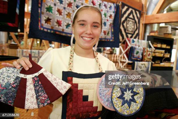 An Amish teen girl selling quilt potholders at American Countryside Farmers Market.