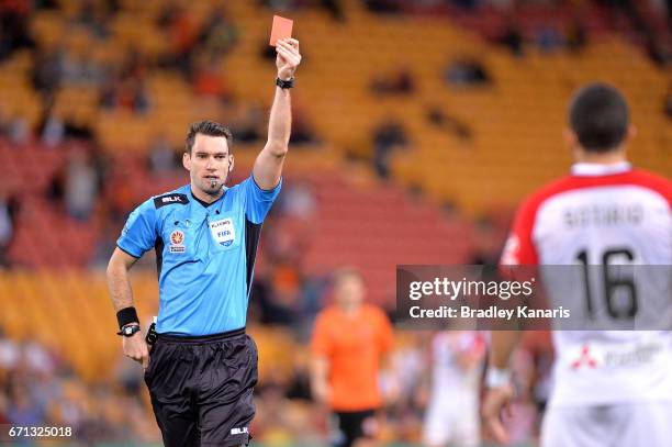 Referee Jarred Gillett hands out a red card to Jaushua Sotirio of the Wanderers during the A-League Elimination Final match between the Brisbane Roar...