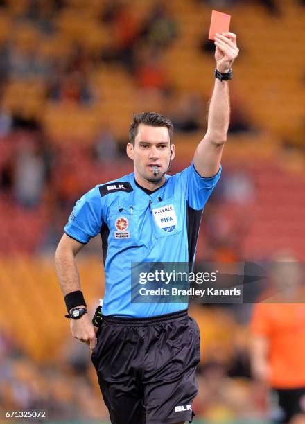 Referee Jarred Gillett hands out a red card to Jaushua Sotirio of the Wanderers during the A-League Elimination Final match between the Brisbane Roar...