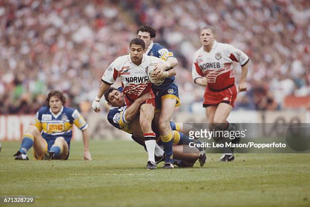 English rugby league player Jason Robinson of Wigan is tackled as he advances with the ball during the final of the 1995 Silk Cut Challenge Cup rugby...