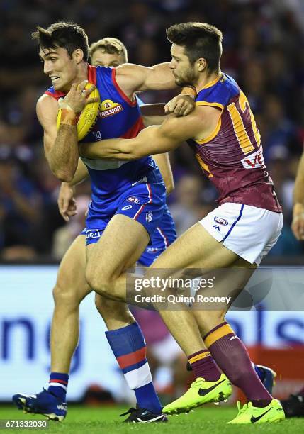 Tom Campbell of the Bulldogs fends off a tackle by Stefan Martin of the Lions during the round five AFL match between the Western Bulldogs and the...