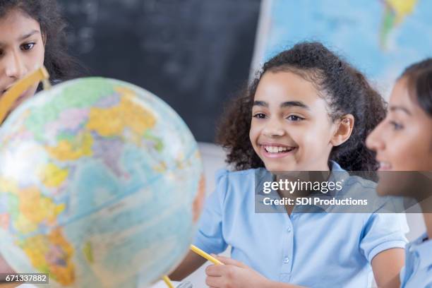 amigos felizes miran mundo juntos en clase - physical geography fotografías e imágenes de stock