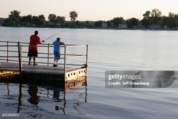 Two boys fishing off of the pier at Pine Lake.