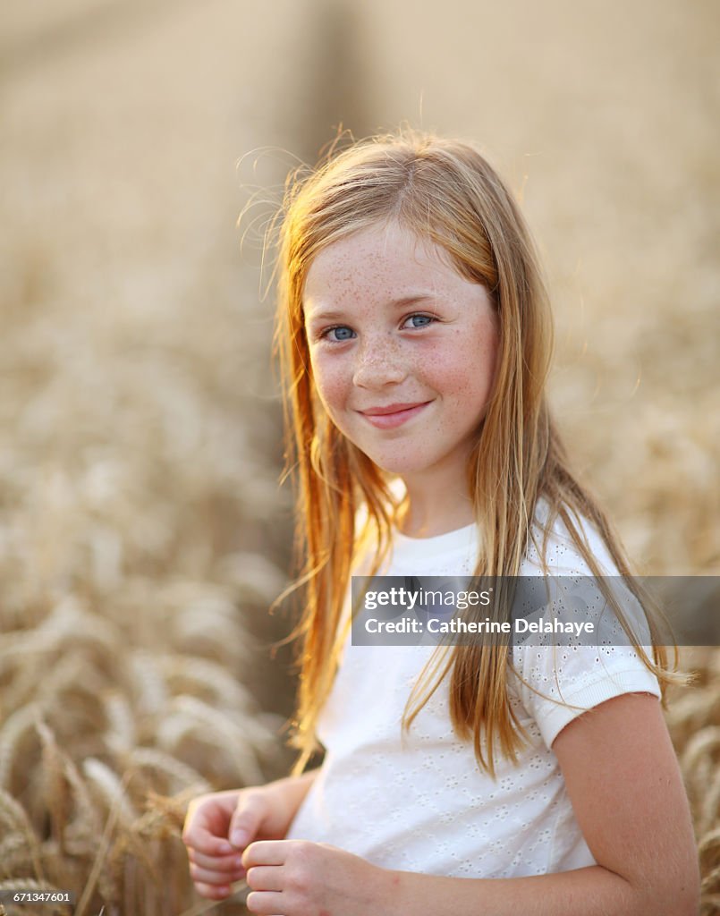 A 8 years old girl in a wheat field