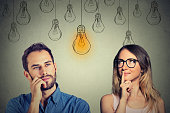 man and woman looking at bright light bulb