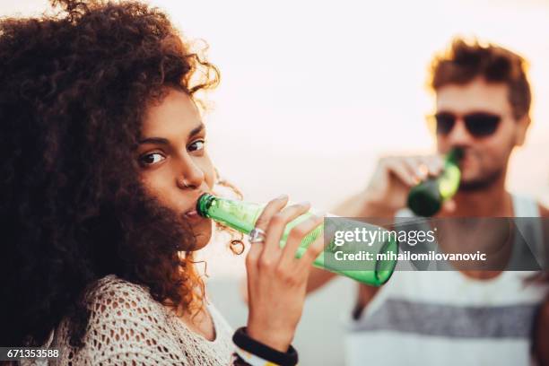 meisje bier drinken - african girls on beach stockfoto's en -beelden