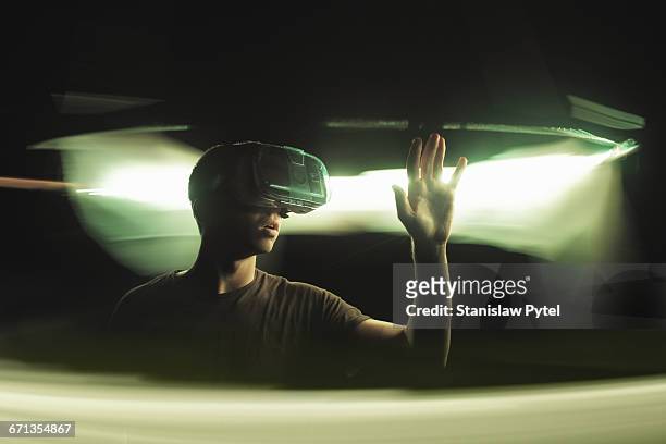 man using vr goggles, touching light - virtualitytrend stock-fotos und bilder