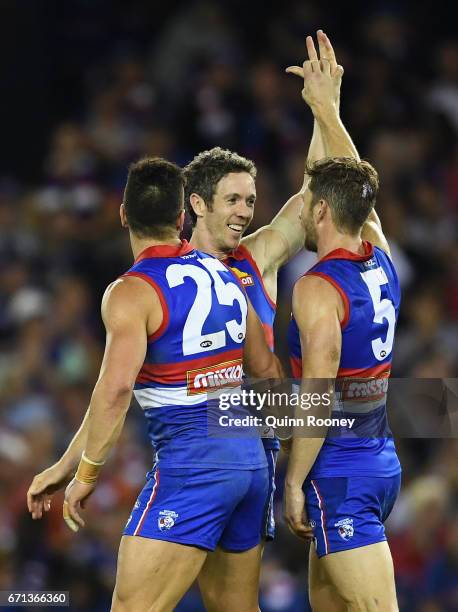 Robert Murphy of the Bulldogs is congratulated by Marcus Adams and Matthew Boyd after winning in his 300th game during the round five AFL match...