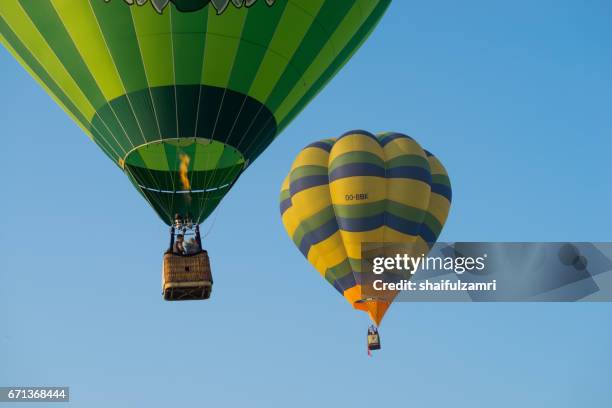 myballoon fiesta in putrajaya features colorful hot air balloon floats with over 15 balloonists from all over the world. - zone d'exclusion aérienne photos et images de collection