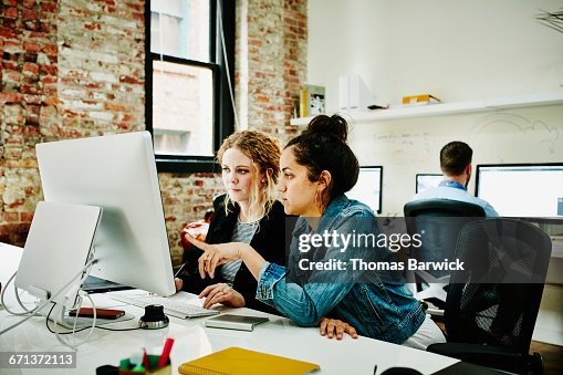 Programmers working on coding project on computer Programmers working on coding project on computer