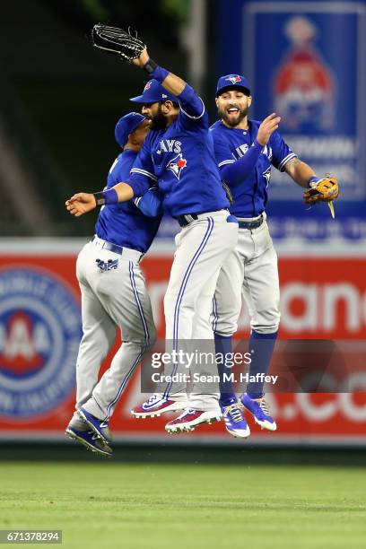 Ezequiel Carrera, Jose Bautista, and Kevin Pillar of the Toronto Blue Jays celebrate defeating the Los Angeles Angels of Anaheim 8-7 in a thirteen...