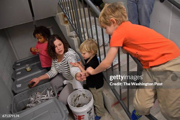 Carrie Brownlie hands out worms to from left, Jade Neal Asher Brownlie and Joseph Brownlie, as she feeds the worms compost mixed with shredded...