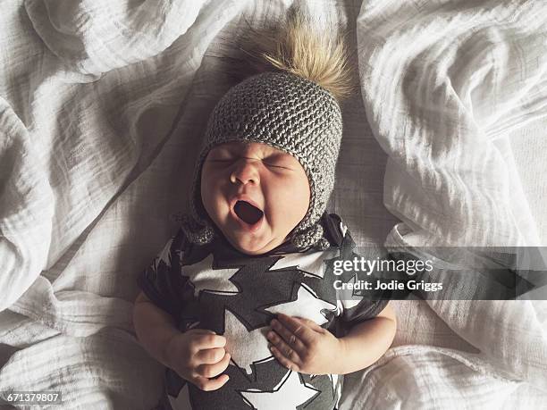 infant waking up yawning after a big sleep - baby onesie stock pictures, royalty-free photos & images