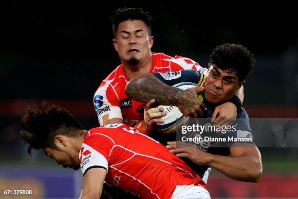 Malakai Fekitoa of the Highlanders tries to break the tackle of Yasutaka Sasakura and Yu Tamura of the Sunwolves during the round nine Super Rugby...