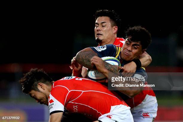 Malakai Fekitoa of the Highlanders tries to break the tackle of Yasutaka Sasakura and Yu Tamura of the Sunwolves during the round nine Super Rugby...