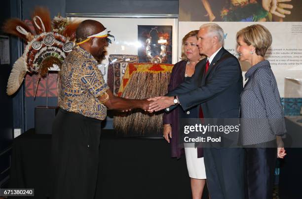 Vice President Mike Pence standing next to Australian Foreign Minister Julie Bishop , shakes hands with Dr Michael Mel, wearing a traditional Papa...