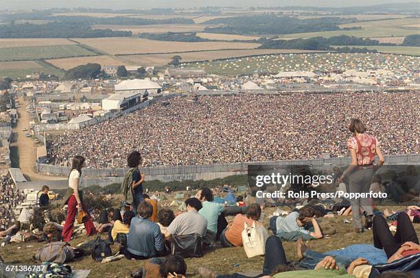 View from the top of Afton Down hill as hippies and members of the audience are pictured sitting on the grass as they look down on events behind the...