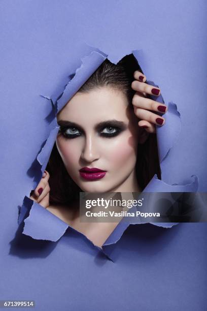 beautiful woman looking through paper - black eyeshadow stock pictures, royalty-free photos & images