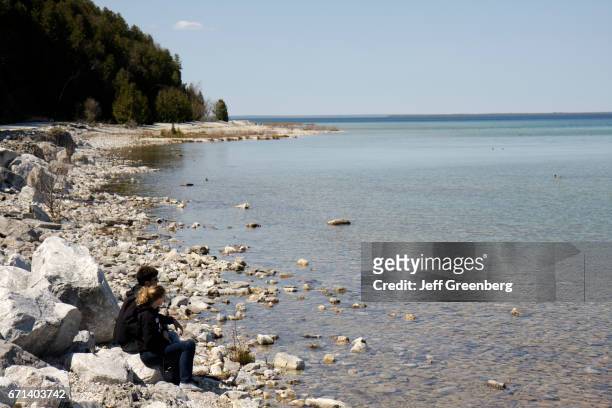 Couple sat on the rocks at Lake Huron.