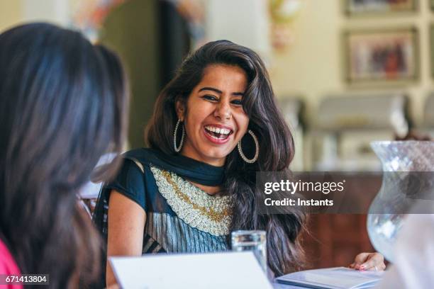 junge indische mann und zwei frauen verbringen einige zeit zusammen in einem restaurant in jodhpur. - friendly small business talking stock-fotos und bilder