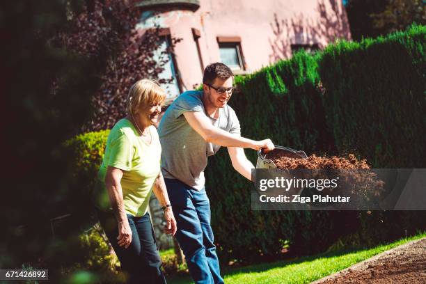 helping seniors with gardening - lawn fertilizer stock pictures, royalty-free photos & images