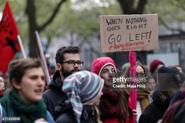 Protester holds up a sign reading 'When nothing goes right go left!' as she demonstrates against the right-wing populist Alternative for Germany...