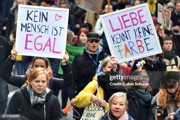 Protesters hold up signs reading 'No one is illegal' and 'Love doesnt know colours' as they demonstrate against the right-wing populist Alternative...