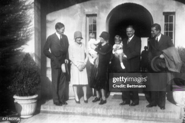 At home again in Palo Alto, California. This photo shows left to right, Herbert Hoover Jr., Mrs. Herbert Hoover, Jr., Mrs. Herbert Hoover holding...