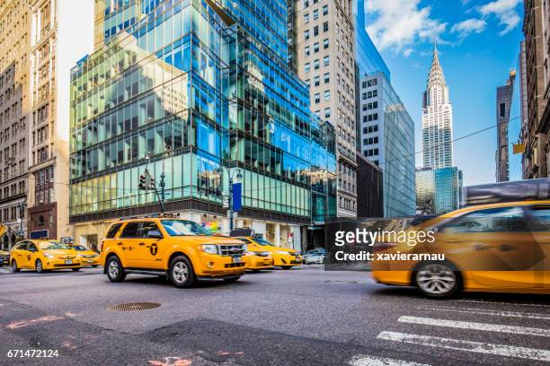 gelben taxis an viel befahrenen straße in new york city - midtown manhattan stock-fotos und bilder