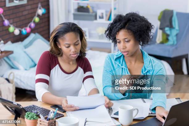 young women work together on something in college dorm room - college preparation stock pictures, royalty-free photos & images