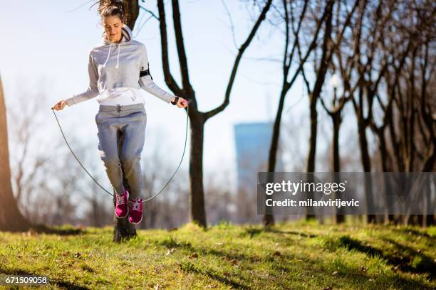 jonge vrouw springtouw in het park - jump rope stockfoto's en -beelden