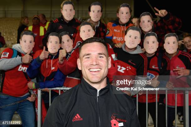 Ryan Crotty of the Crusaders poses in front of Crusaders fans wearing Ryan Crotty masks following the round nine Super Rugby match between the...