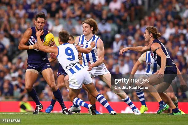 Michael Johnson of the Dockers looks to avoid being tackled by Andrew Swallow of the Kangaroos during the round five AFL match between the Fremantle...