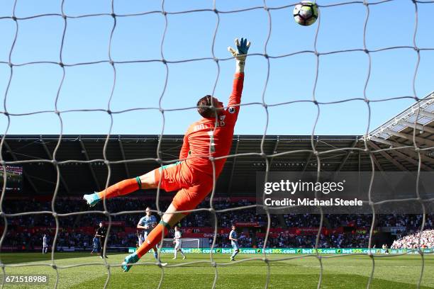 Jack Butland of Stoke City attempts to save as Tom Carroll of Swansea City scores his sides second goal during the Premier League match between...