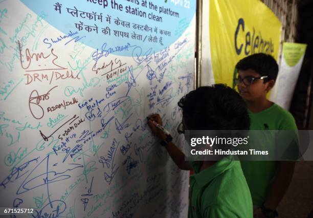 School children and Safai Sena members educating the public on the International Earth day at the New Delhi Railway station, on April 22, 2017 in New...