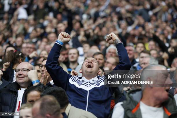 Tottenham Spur's fan celebrates after his team scores during the FA Cup semi-final football match between Tottenham Hotspur and Chelsea at Wembley...