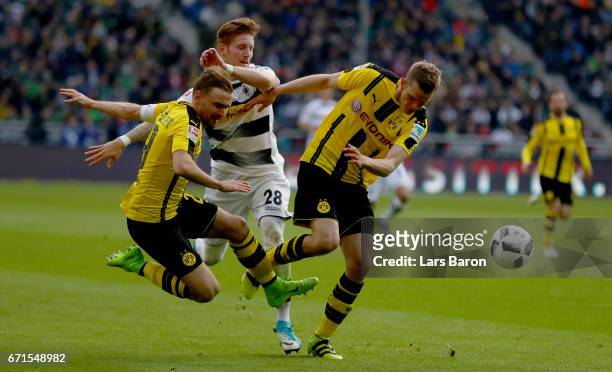 Andre Hahn of Moenchengladbach is challenged by Marcel Schmelzer of Dortmund and Sven Bender of Dortmund during the Bundesliga match between Borussia...