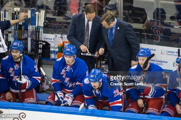Head coach Alain Vigneault and associate coach Scott Arniel of the New York Rangers review a play on iPads placed on the benches during the game...