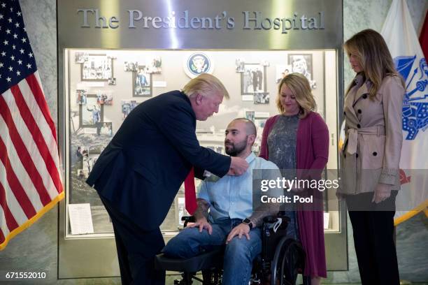 President Donald Trump , with First Lady Melania Trump , awards Sergeant First Class Alvaro Barrientos , with his wife Tammy Barrientos , the Purple...