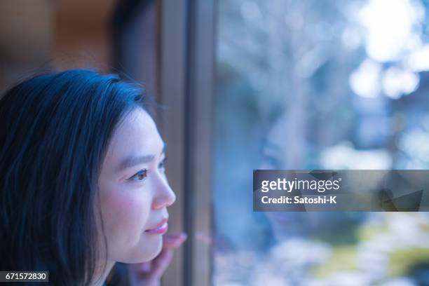 若い女性の窓の外には、朝 - 若い女性 日本人 顔 ストックフォトと画像