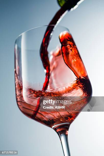 red wine pouring in glass - merlot stock pictures, royalty-free photos & images